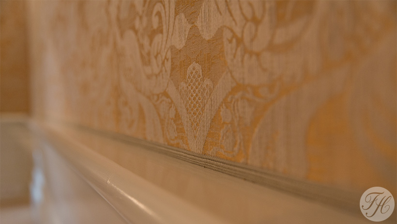 detail gele wandbespanningstof afgewerkt met passend koord souterrain Keizersgracht