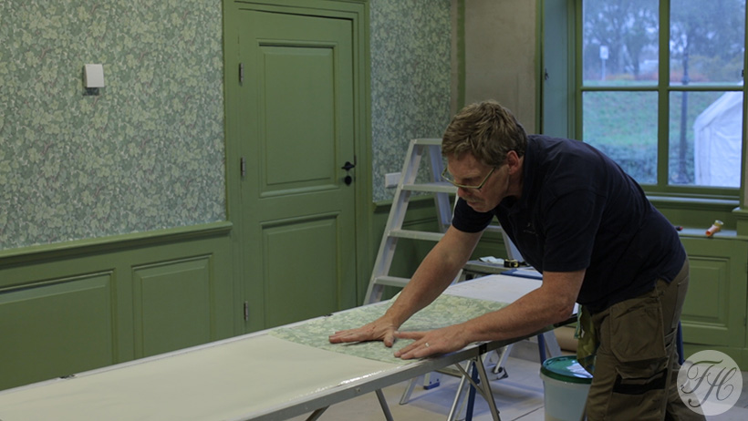Aanbrengen behang op klassieke betengeling in Streekmuseum Hoeksche Waard boerderij Oost Leeuwenstein te Heinenoord