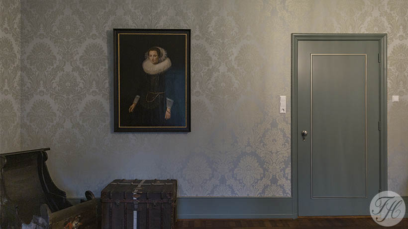 Muur bespannen met een damast stoffen wandbespanning en is afgewerkt met koord