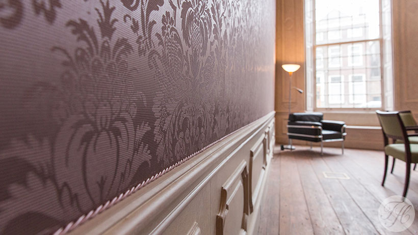 gegaufreerd zijden wandbespanning in stijlkamer afgewerkt met koord